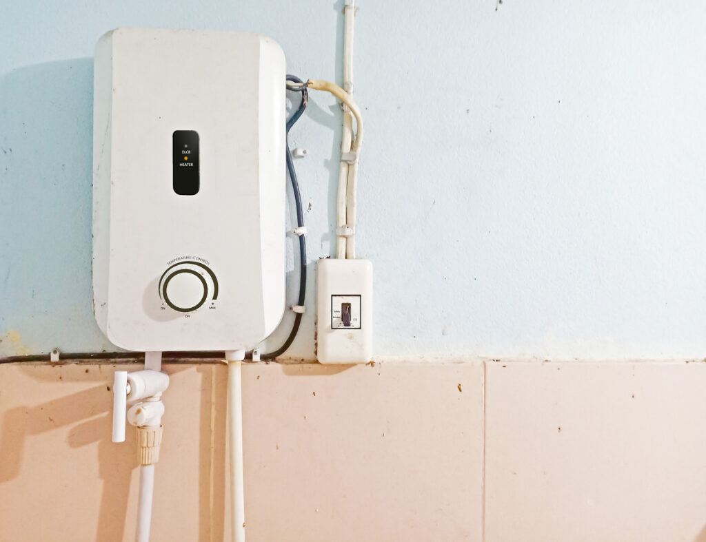 White tankless water heater installed with circuit breaker on the wall of bathroom